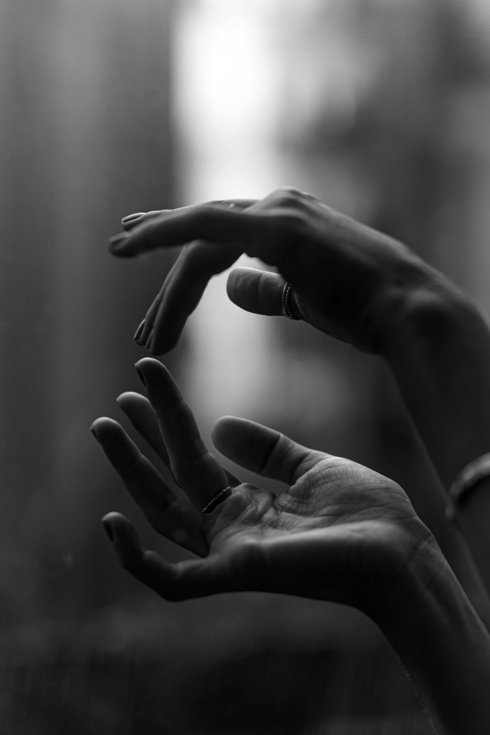 Elegant black and white close-up of hands with blurred background.